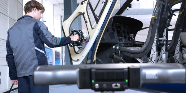 Un mécanicien réalisant un scan 3d d'une porte d'hélicoptère pour maintenance prédictive