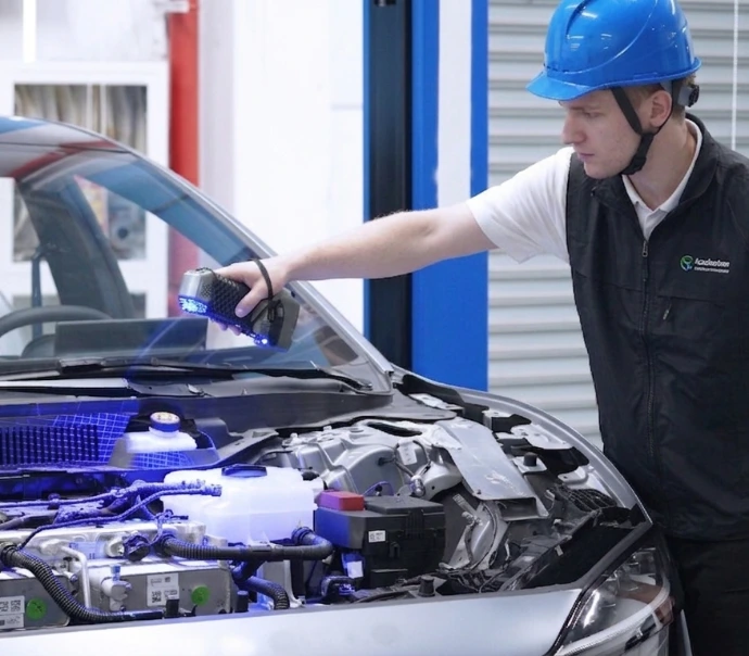 Un opérateur scannant le compartiment moteur d'un véhicule pour de l'ingénierie