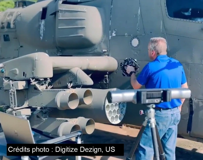 Un homme numérisant en 3d la surface d'un hélicoptère Apache