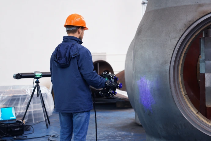 Un contrôleur qualité vérifiant une pièce de fonderie avec un Trackscan