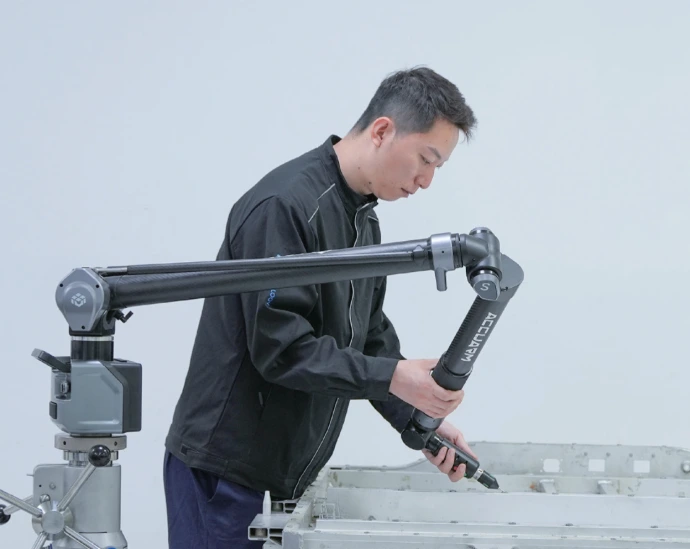 Un métrologue inspection un objet forgé avec le bras de mesure AccuArm de Scanology